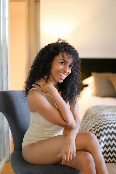 Jeune belle fille noire assise dans la chambre et portant de la lingerie beige . — Photo