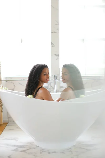 Zwart meisje nemen bad en ontspannen, reflectie in glas. — Stockfoto