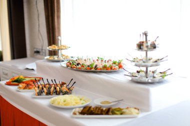 Masada beyaz masa örtüsü ile nefis ziyafet yemekleri.