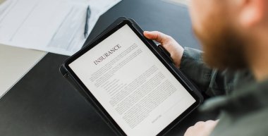 Komisyoncu ofisteki tablet ekranda sigorta okuyor.