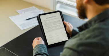 Tablette satış sözleşmesi imzalayan adam.