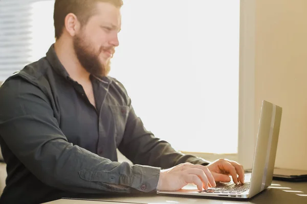 Junger Konstrukteur arbeitet mit Laptop im Büro und sucht Ideen. — Stockfoto