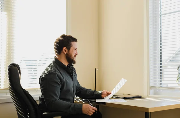 Pensando business boss seduto in ufficio con documenti, tablet sul tavolo . — Foto Stock