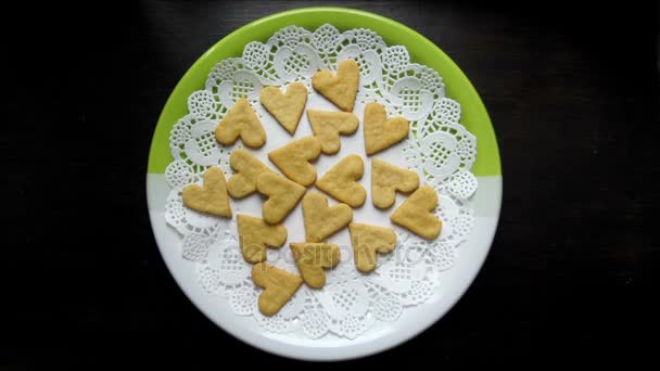 Cookies em forma de coração aparecem em uma animação de movimento de parada de placa — Vídeo de Stock