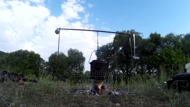 Kochen von Essen am Lagerfeuer am Fluss — Stockvideo