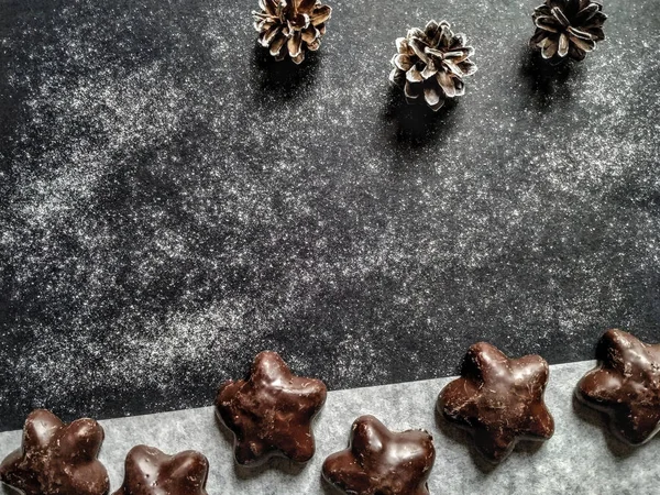 Dark chocolate cookies and fir-cones on a granite background — 스톡 사진