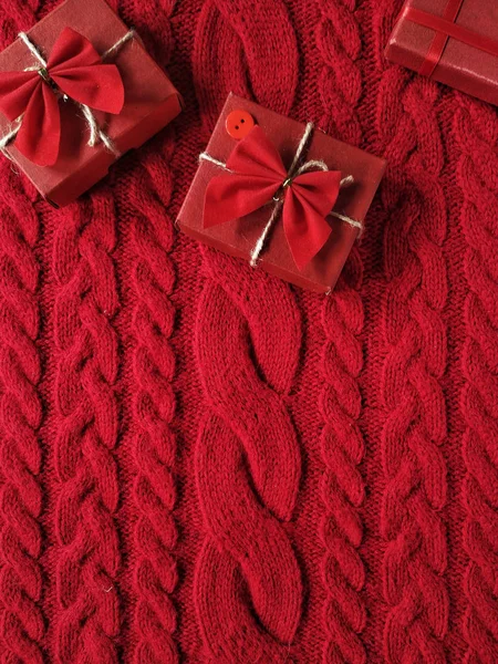 Gift boxes with a bows on a knitted sweater in red colours for V — Stock Photo, Image