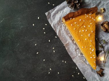 Beyaz buruşmuş kağıtta siyah bir parça balkabaklı cheesecake.