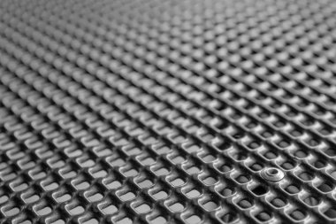 Siyah, ince bir metal ağ arka planında perçin