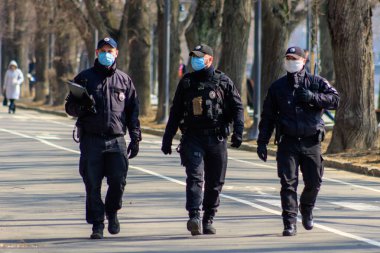 Uzhgorod, Ukrayna - 18 Mart 2020: Koronavirüs nedeniyle şehir merkezinde devriye gezen sağlık maskeli polisler.