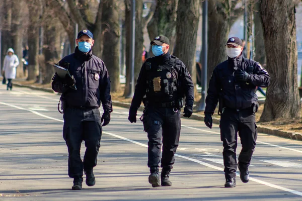 Uzhgorod, Ukrayna - 18 Mart 2020: Koronavirüs nedeniyle şehir merkezinde devriye gezen sağlık maskeli polisler.