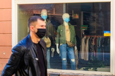 Uzhgorod, Ukrayna - 8 Nisan 2020: Koruyucu maskeli erkek ve kadın mankenler bir gençlik giyim mağazasının vitrininde duruyorlar. Karantina sırasında şehir hayatı.
