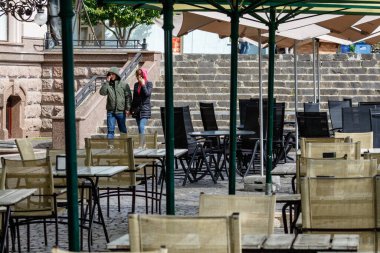 Uzhgorod, Ukrayna - 12 Mayıs 2020: İnsanlar koronavirüs enfeksiyonu nedeniyle karantinayı zayıflattıktan sonra restoranların boş teraslarına yakın yürüyorlar.
