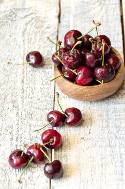 Kiraz ahşap arka plan üzerinde ahşap bir fincan