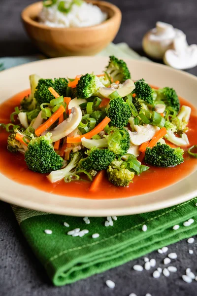 Broccoli aburit cu ciuperci, morcov și ceapă, servit cu sos de roșii și orez — Fotografie, imagine de stoc