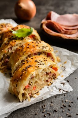 Savory strudel with sour cabbage, bacon and onion clipart