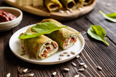 Ispanaklı krep beyaz peynir, lor, güneş kurutulmuş domates ve ayçiçeği tohumu ile doldurulmuş