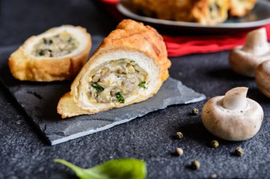 Hamuru kaplı ve içi doldurulmuş mantar, peynir, soğan ve maydanoz ile kızarmış rulolar                 