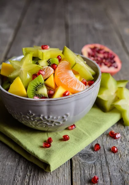 Fruktsallad med kiwi, mango, mandarin, carambola och granatäpple — Stockfoto