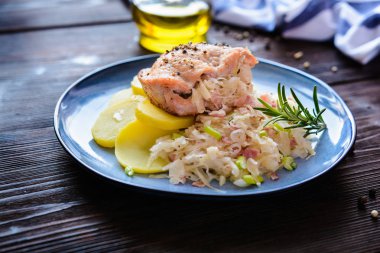 Kızarmış domuz eti ile patates hizmet ekşi lahana ve domuz pastırması parçaları ile doldurulmuş