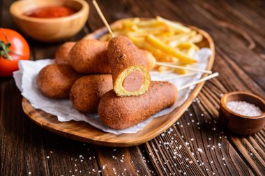 Patates kızartması, ketçap ve hardal ile corndogs