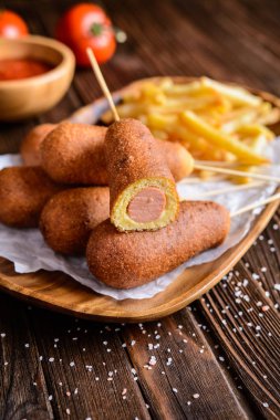 Patates kızartması, ketçap ve hardal ile corndogs