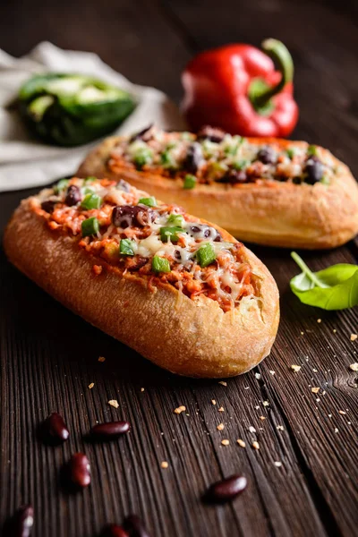 Baguette gefüllt mit Hackfleisch, Tomatensauce, Paprika, Bohnen, Zwiebeln, Knoblauch und Käse — Stockfoto
