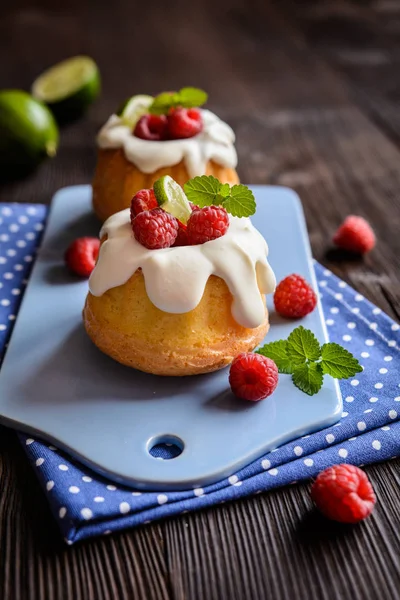 Mini lime bundt cakes with whipped cream and raspberries topping — Stock Photo, Image
