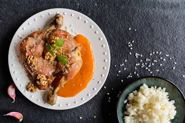 Жареные куриные бёдра посыпанные грецкими орехами, подаются с абрикосовым соусом и рисом — стоковое фото