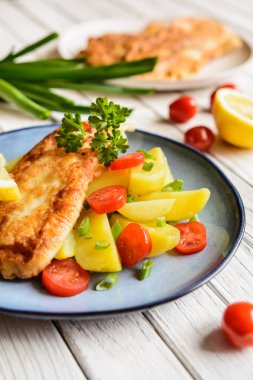 Kızarmış Balık silmeleri meyilli, patates, domates, yeşil soğan ile servis