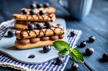 Savoiardi kakao krema ile doldurulmuş ve çikolata ve yaban mersini ile tepesinde