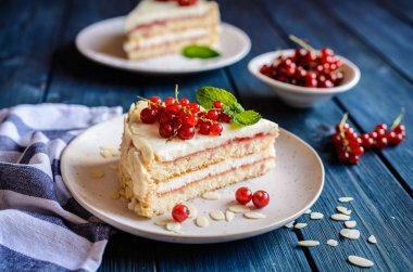 Lezzetli kek mascarpone, krem şanti, frenk üzümü ve badem dilimleri