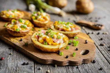 Patates tekneler Mısır, jambon, peynir ve yeşil soğan ile dolu