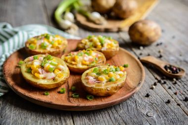 Patates tekneler Mısır, jambon, peynir ve yeşil soğan ile dolu