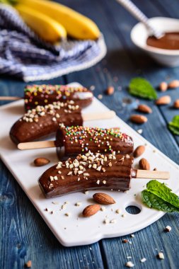 Kıyılmış badem ve renkli şeker serpilir ve çikolata kaplı muz