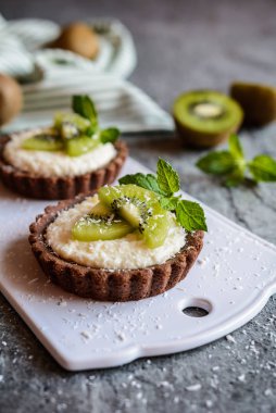Çikolata tartlets Hindistan cevizi kreması ile dolu ve kivi dilimleri ile tepesinde