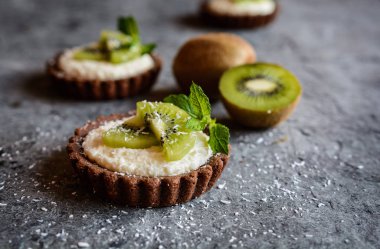 Çikolata tartlets Hindistan cevizi kreması ile dolu ve kivi dilimleri ile tepesinde