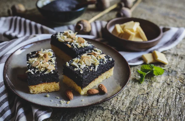 Pandispanya haşhaş tohumu tabaka, beyaz çikolata bukleler ile dekore edilmiş ve dilimlenmiş badem