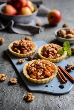 Karamelize elma parçaları, tarçın ve ceviz meyve tartlets dolu
