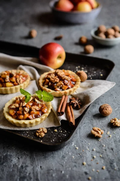 Karamelize elma parçaları, tarçın ve ceviz meyve tartlets dolu