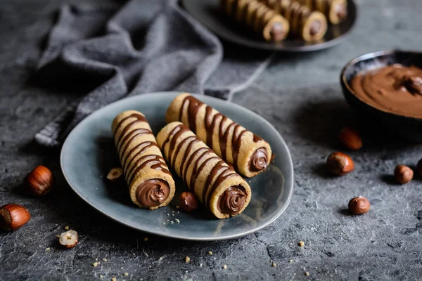 Tubos de biscoito preenchidos com creme de avelã e cobertura de chocolate — Fotografia de Stock