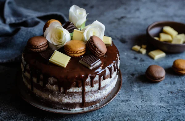 Tort gol umplut cu cremă de mascarpone, acoperit cu ciocolată și decorat cu flori, macaroane și bucăți de ciocolată — Fotografie, imagine de stoc