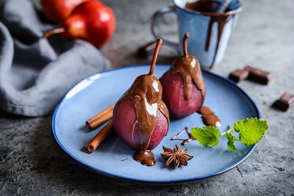 Haşlanmış armut kırmızı şarap ve çikolata sosu ile tepesinde — Stok fotoğraf