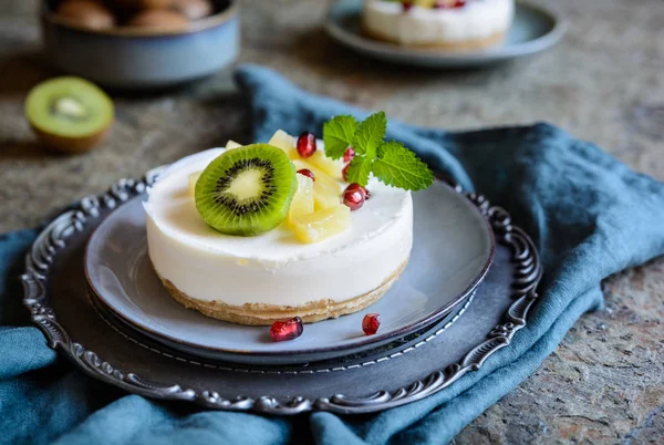 Unbaked mini cheesecakes topped with pineapple, kiwi and pomegranate — Stock Photo, Image