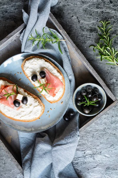 Кусочки хлеба со сливочным спредом из сыра Фета, хрена и сметаны, подается с ветчиной Шварцвальда и черными оливками — стоковое фото