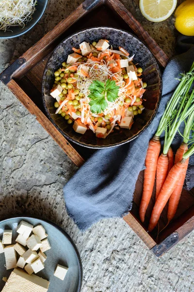 Легкий веганский салат с вареным зеленым горошком, ломтиками корня петрушки и морковью, копченым тофу и ростками люцерны — стоковое фото
