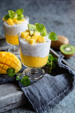 Vejetaryen hindistancevizi chia tohumu pudingi, mango püresi ve kivi dilimleriyle kaplı.