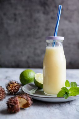 Tropikal içecekleri tazeleyen ananas ve hindistan cevizi sütüyle karıştırılmış rambutan smoothie.