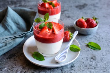 Çilek soslu geleneksel Panna cotta, cam kavanozda servis edilir.