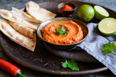 Muhammara, sağlıklı ceviz ve kavrulmuş kırmızı dolma biber sosu seramik bir kasede yassı ekmekle servis edilir.